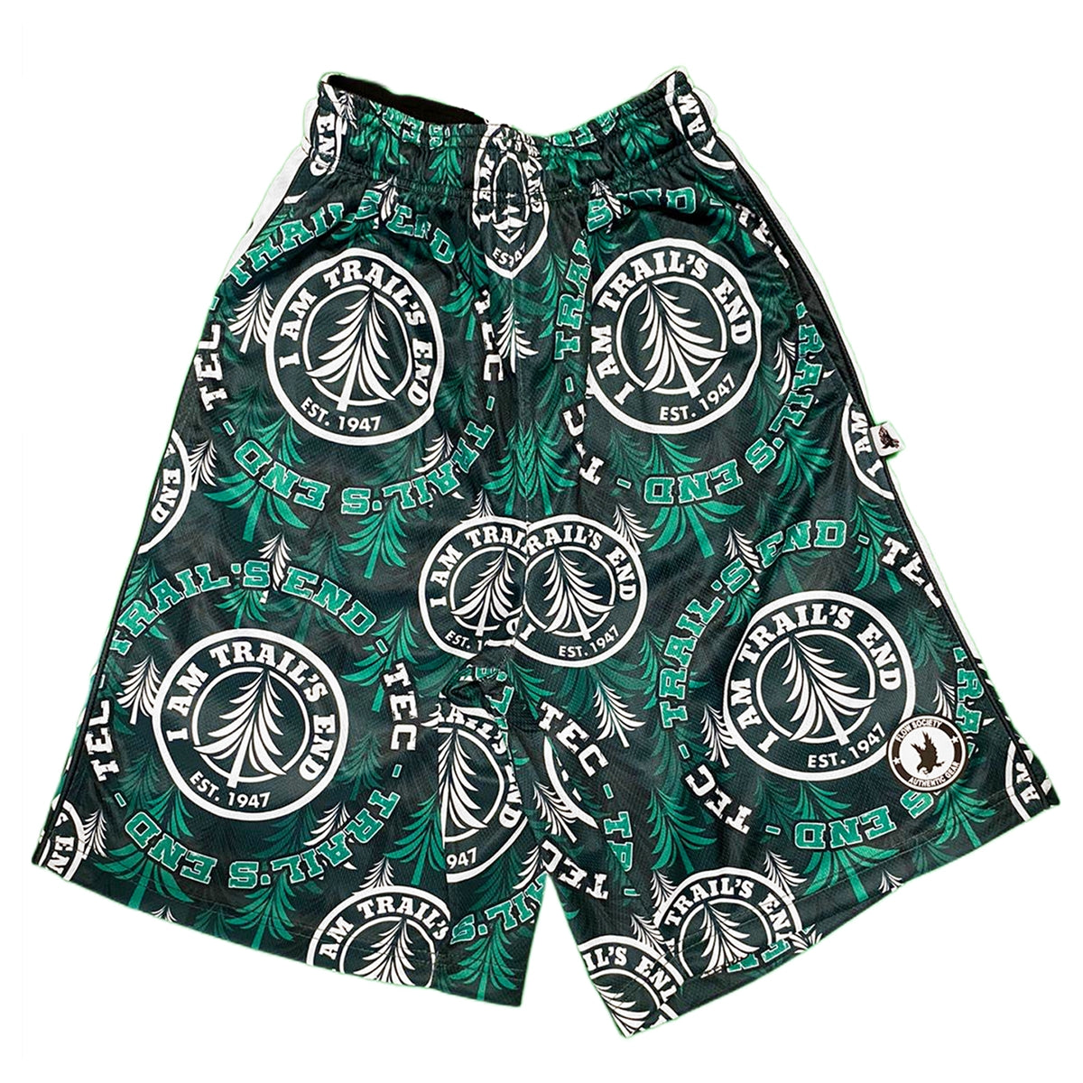 Green and black athletic shorts with repeating circular Trail's End logo and pine tree pattern