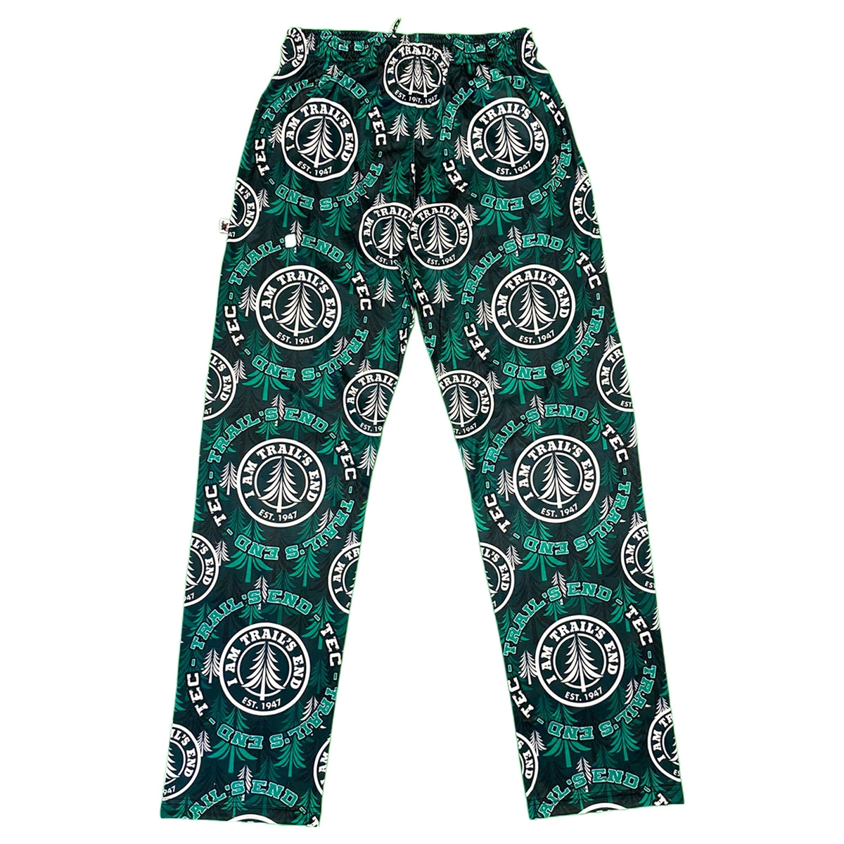 Green and black lounge pants with repeating circular Trail End Camp logo and pine tree pattern