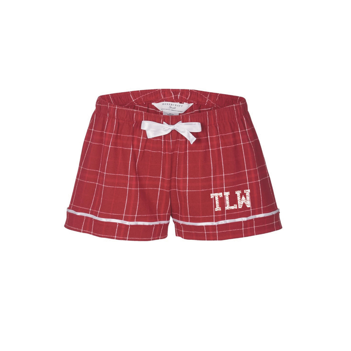 Red plaid pajama shorts with white trim and white ribbon bow featuring TLW monogram