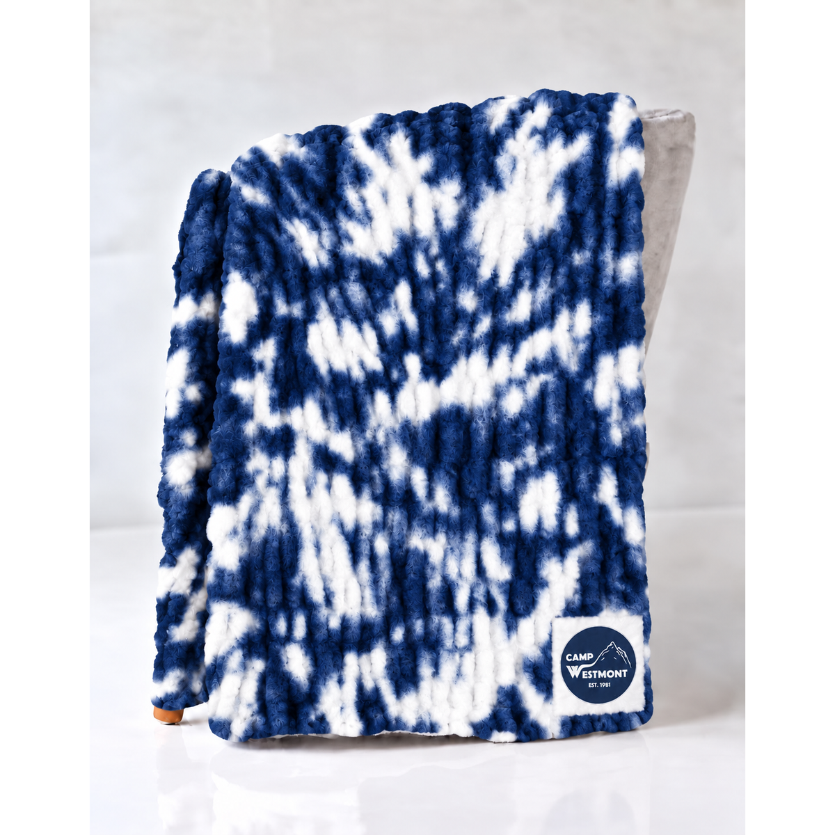 Blue and white tie dye plush throw blanket with Camp Westmont logo patch
