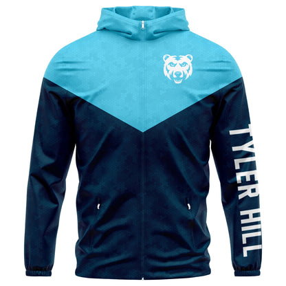 Light blue and navy zip up hooded windbreaker with bear logo and Tyler Hill text on sleeve